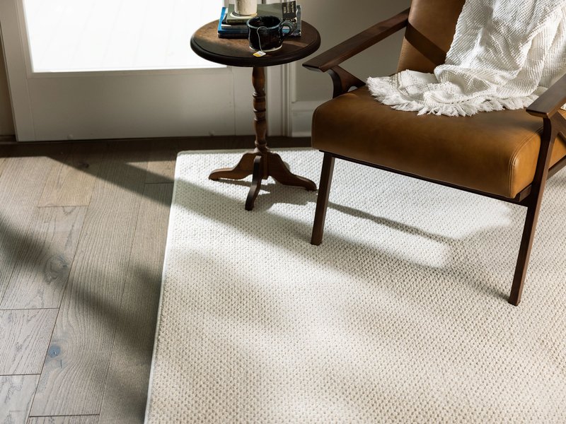 wood and leather chair on white area rug